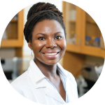 A headshot of Dr. Renee Cottle, proudly wearing her lab coat. Her hair is wrapped up in a high bun.